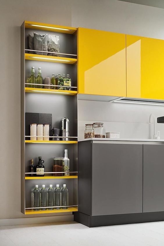 A bright, minimalist kitchen with sleek yellow and gray cabinets and a light gray backsplash looks cool and very chic