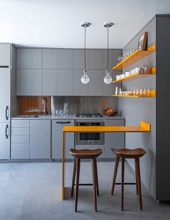 a chic, minimalist kitchen with matte gray cabinets, sunny yellow shelves and a matching counter for meals and drinks
