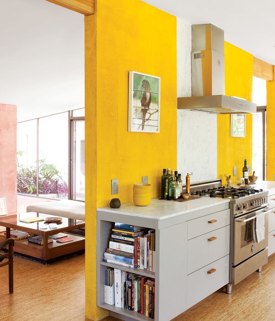 A sunny yellow kitchen with modern gray cabinets and stainless steel appliances, as well as eye-catching artwork, is a statement piece from Veyr