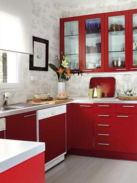 A bright, modern red kitchen with wallpaper walls, white stone countertops and simple handles and artwork is amazing
