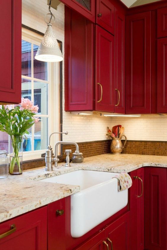 A super strong red vintage kitchen with two types of tiles on the back wall and stone countertops looks very chic and elegant