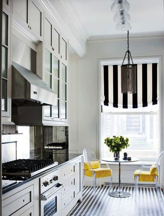 a chic kitchen with farmhouse furniture, a striped curtain that coordinates with the floors, a round table and acrylic chairs with yellow upholstery