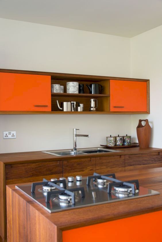A bright, modern kitchen with richly stained wood cabinets and bright orange accents is very spectacular