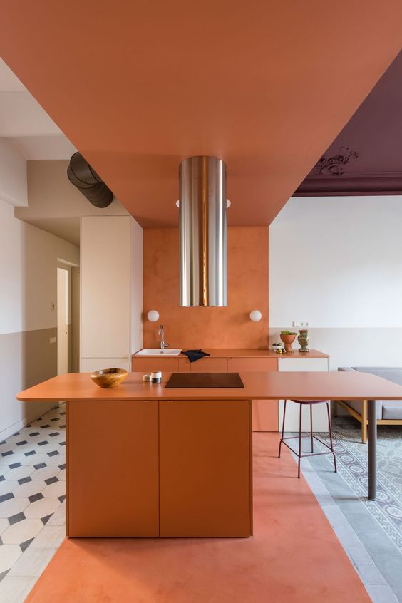 A sophisticated burnt orange kitchen with sleek matte cabinets, white cabinets, a burnt orange roof and a shiny metal hood