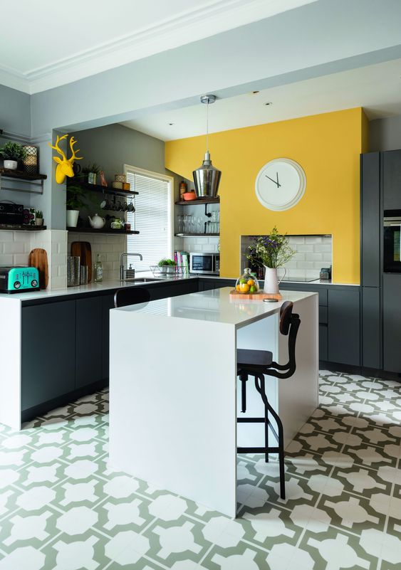 a graphite gray kitchen with white tiles and a sunny yellow touch above the stove to make the kitchen more cheerful
