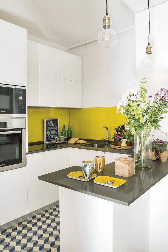 A small white and gray kitchen with simple cabinets and an elegant mustard tile backsplash for a pop of color