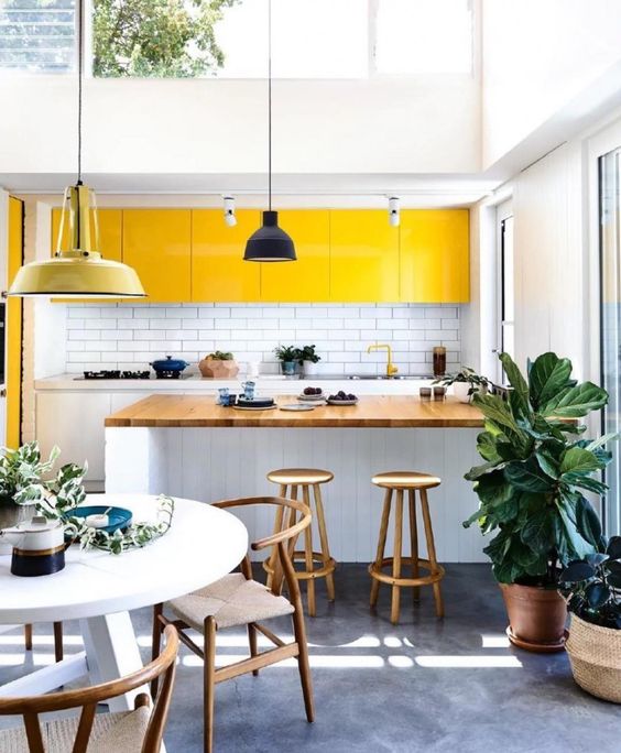 A modern white kitchen with sunny yellow upper cabinets creating a light and bright outdoor feel