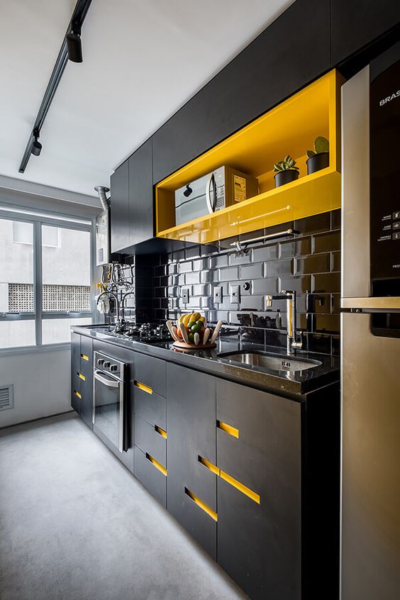 A contrasting black kitchen with bright yellow accents – an open shelf and cut-out handles are super bold