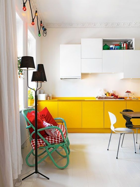 A minimalist kitchen with white upper cabinets and yellow lower cabinets looks airy, bright and cheerful