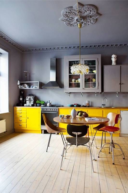a moody gray kitchen with sunny yellow base cabinets that brighten and brighten the entire space