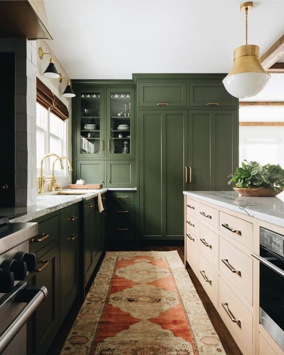 a modern farmhouse kitchen in grass green with white marble countertops and gold accents here and there