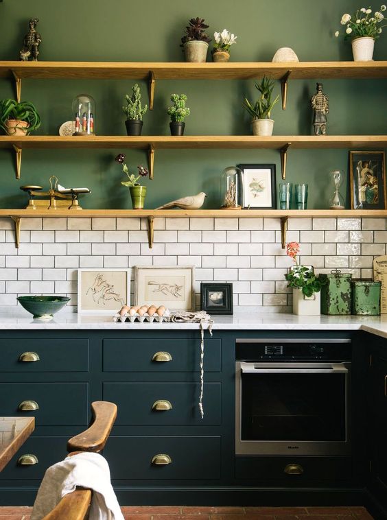 A stylish two-tone kitchen with green walls, hunter green cabinets and a white tile backsplash to refresh