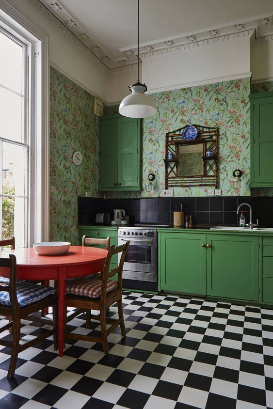 a whimsical, bright green retro kitchen with eye-catching wallpaper walls, a black tile backsplash and a tiled floor