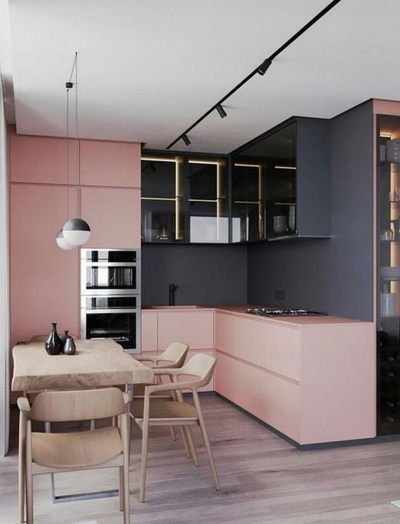 a bold, modern kitchen with black walls, light pink sleek cabinets and illuminated black upper cabinets