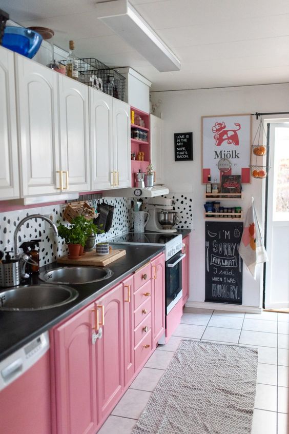a bright and fun kitchen with white upper cabinets, pink lower cabinets and a pretty dolmati print backsplash