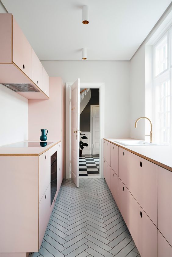 A minimalist blush galley kitchen with sleek cabinets and built-in appliances is very stylish and chic