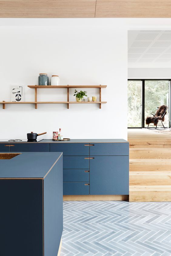 A minimalist navy blue kitchen with open shelves and no handles is a very chic and elegant space with a modern flair