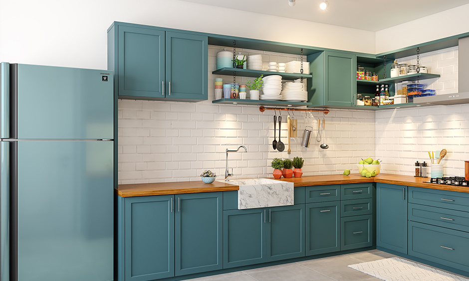 An L-shaped kitchen with a slab corner design and blue cabinets