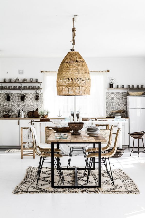 a neutral tropical boho kitchen with mosaic tiles, a wicker lamp, rattan chairs and a printed boho rug