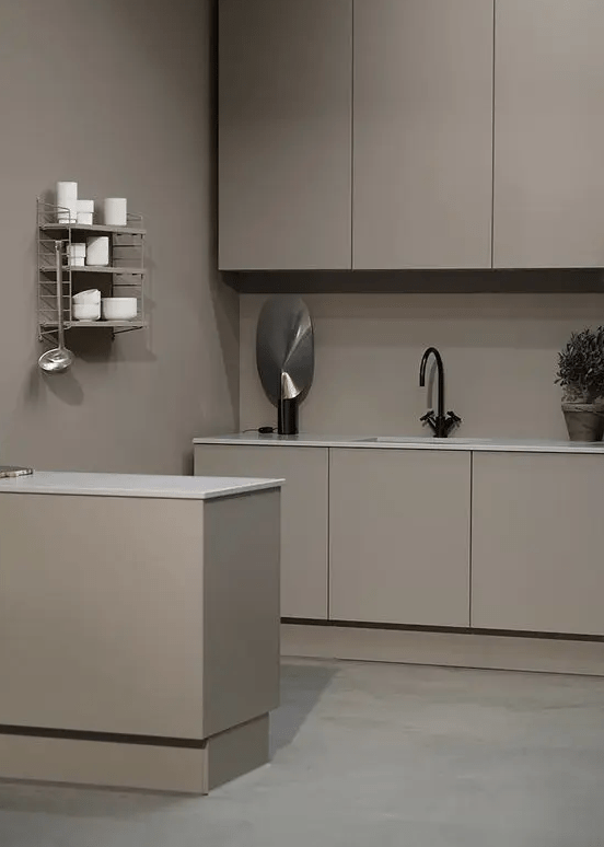 A minimalist taupe kitchen with sleek matte cabinets, a taupe backsplash and white countertops, open shelving and black fixtures is beautiful