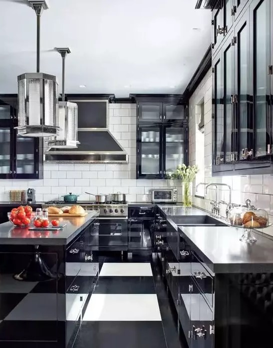 A bold black and white Art Deco kitchen with black cabinets with glass doors, a striped floor, glossy black cabinets and concrete countertops