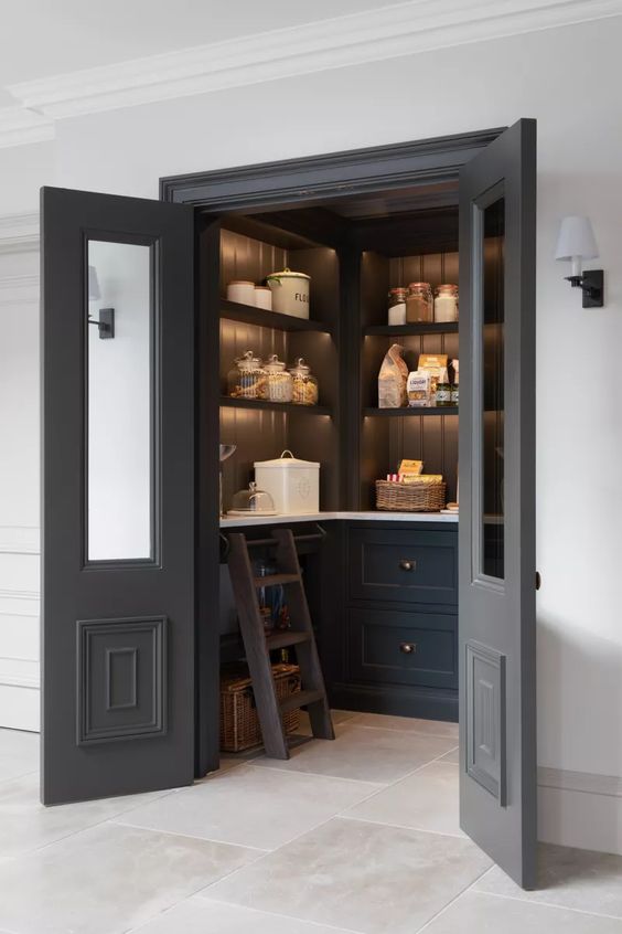 A cool, dark pantry with doors, built-in cabinets and shelves with lights, and a ladder is great for a farmhouse room