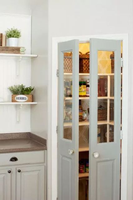 A corner pantry with light gray doors, lights, and built-in open shelves makes a cool storage space