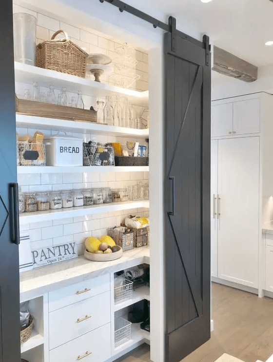 a small and cozy rustic pantry with open shelving and built-in storage cabinets, built-in lights, baskets, jars and wire baskets
