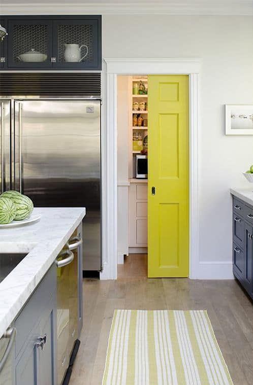 A small walk-in pantry with a neon yellow sliding door, with cabinets, shelves and lights is a cool idea