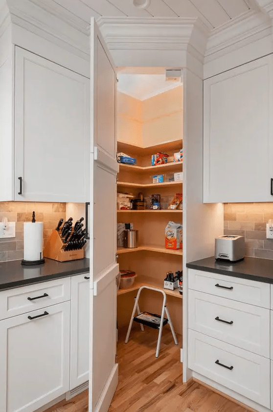 A small hidden pantry with lights, open shelves and a small stool is a clever solution for any kitchen