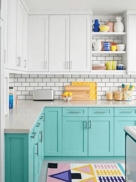 A cheerful turquoise and white kitchen with white subway tiles, colorful accessories and rugs for a fun atmosphere