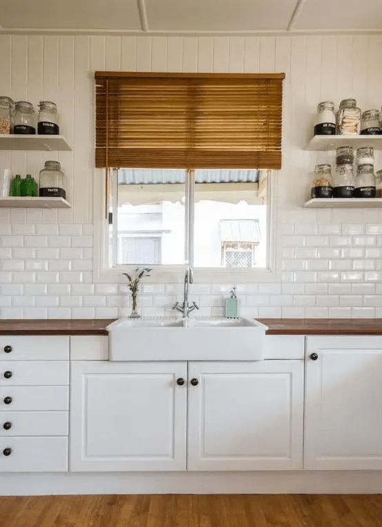 a neutral kitchen with rustic accents, richly stained wood countertops and a white subway tile backsplash
