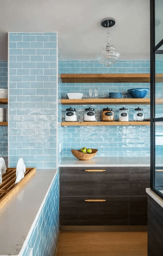 A unique kitchen with light blue subway tiles on the walls, dark cabinets and open shelves is a cool idea