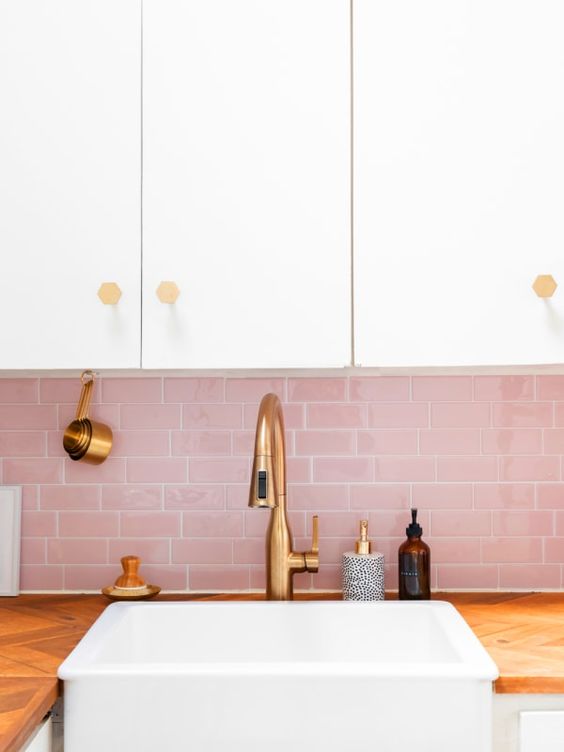 A chic, neutral kitchen with a pink subway tile backsplash and touches of gold for a glamorous and cute look