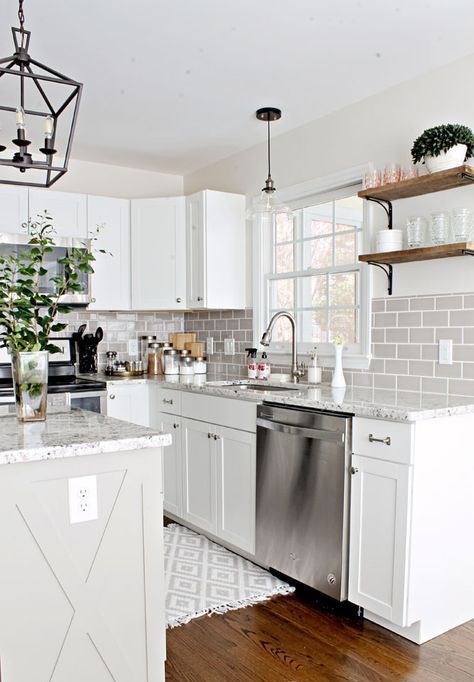 A chic white farmhouse kitchen with terrazzo countertops and a gray subway tile backsplash is very elegant