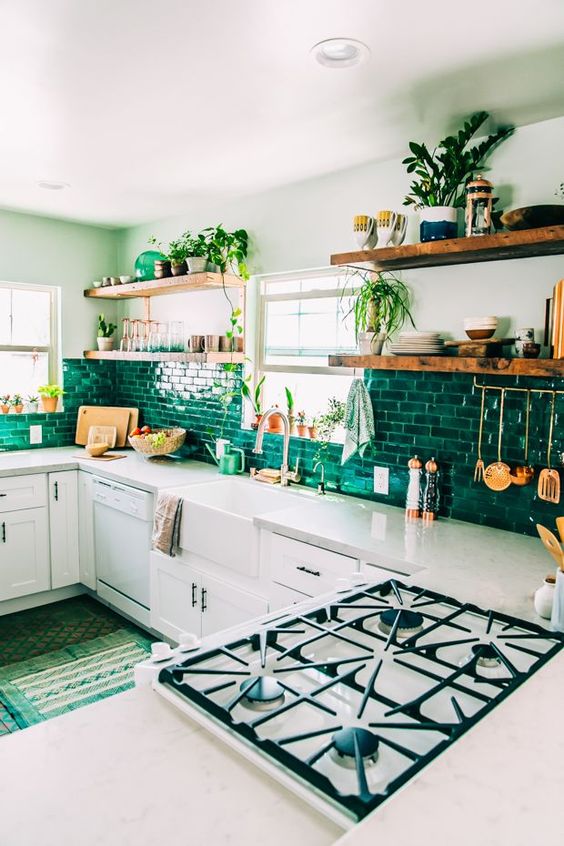 A cozy white kitchen with emerald green subway tiles and wooden shelves is very bright and very stylish