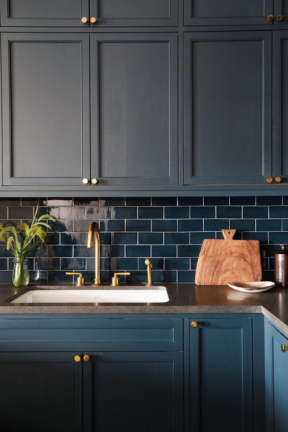 A matte navy kitchen with navy subway tiles and gold accents for a bold and dramatic dark-toned kitchen