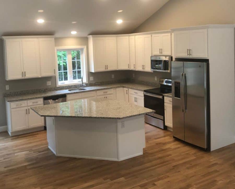 White kitchen cabinet with granite island countertop 
