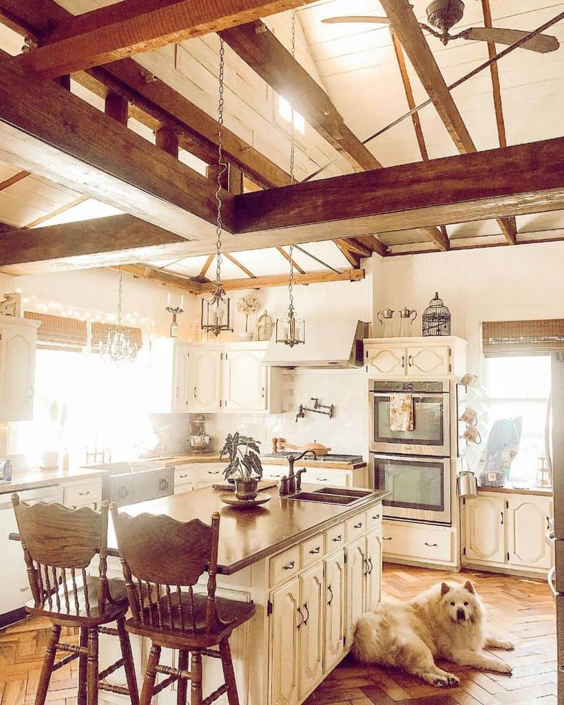 Rustic farmhouse kitchen with white cabinets and exposed beam ceiling 