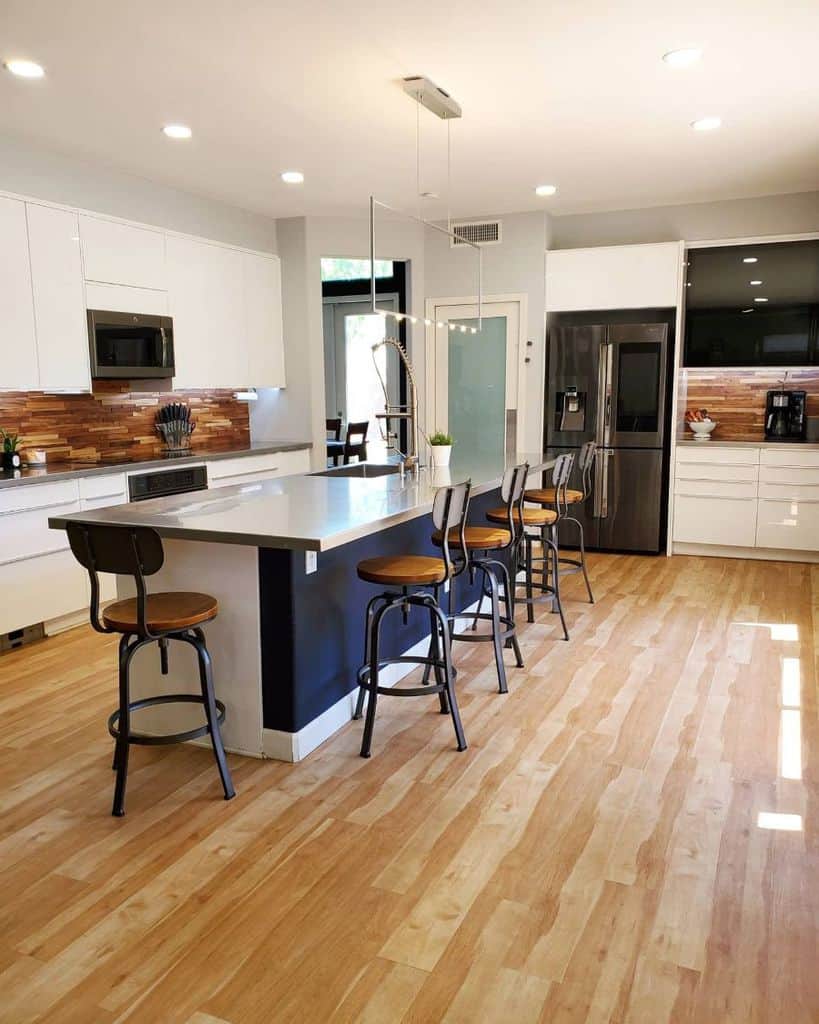 large kitchen with white cabinets and seating around the island 