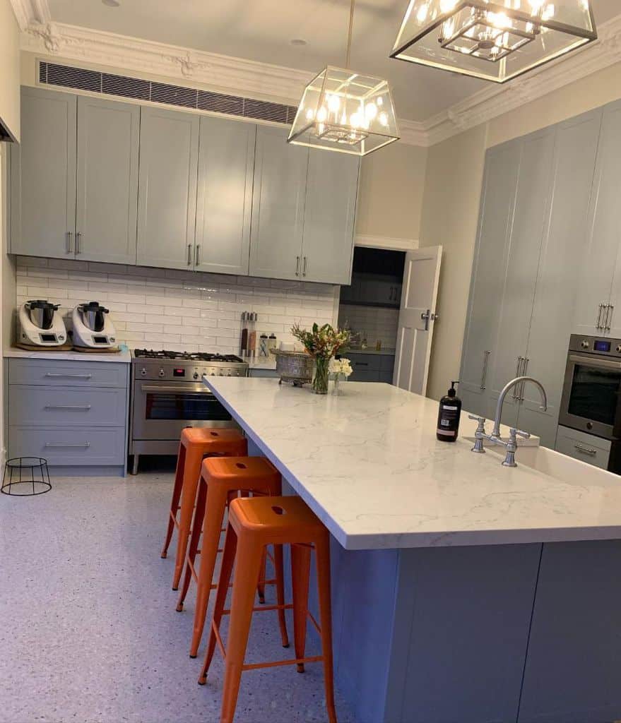 Large marble island in gray cupboard kitchen 