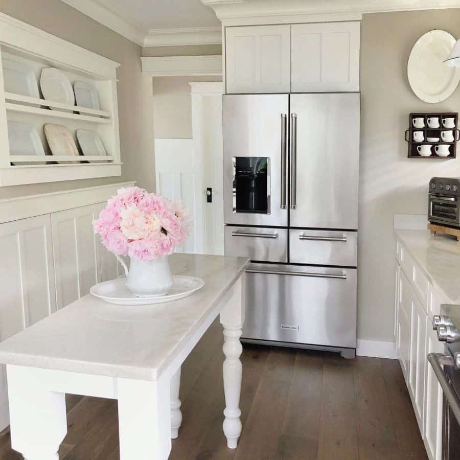 white small kitchen island with silver refrigerator 