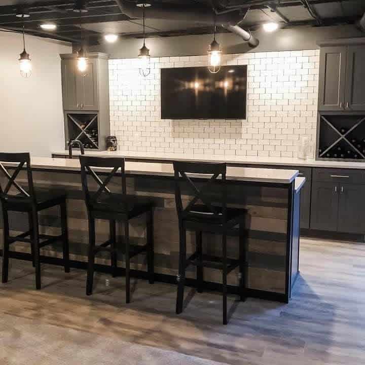 Simple basement bar with white tiled back wall 