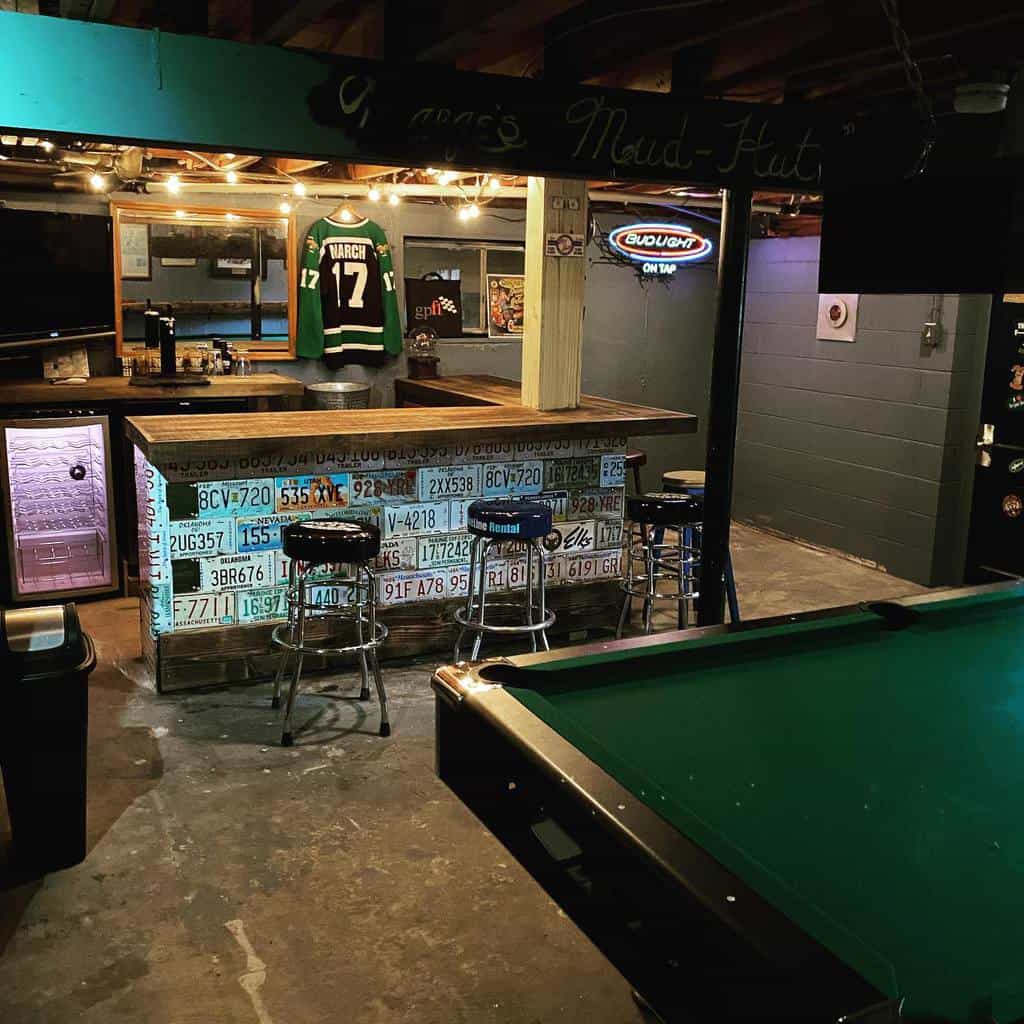 Small sports bar in the basement with a pool table 