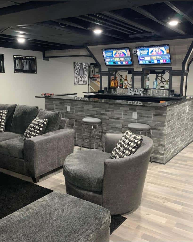 Luxurious gray basement bar with sofas and TV screens