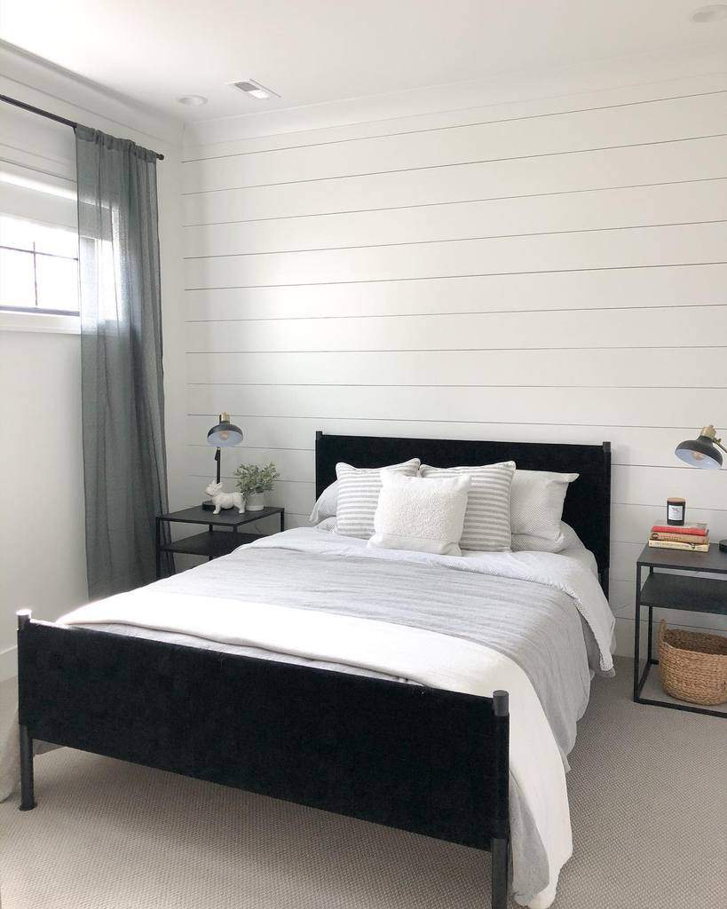 White bedroom with stepped wall and black bed frame 