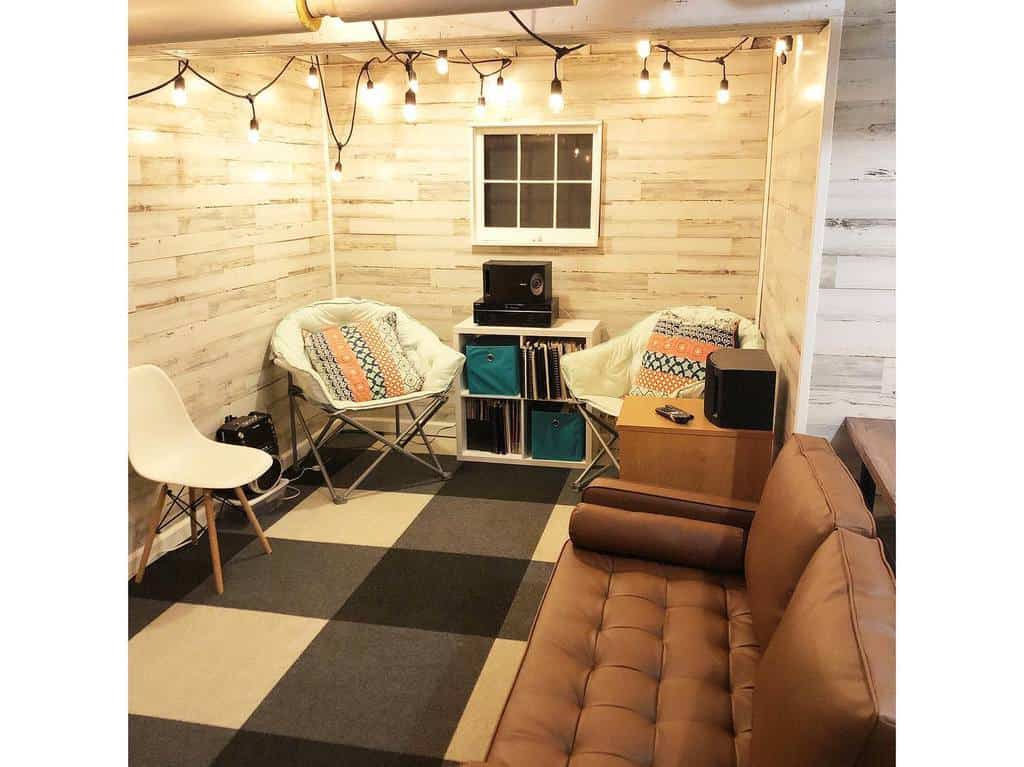 Small, simple living room in the basement with brown sofa and vinyl player 