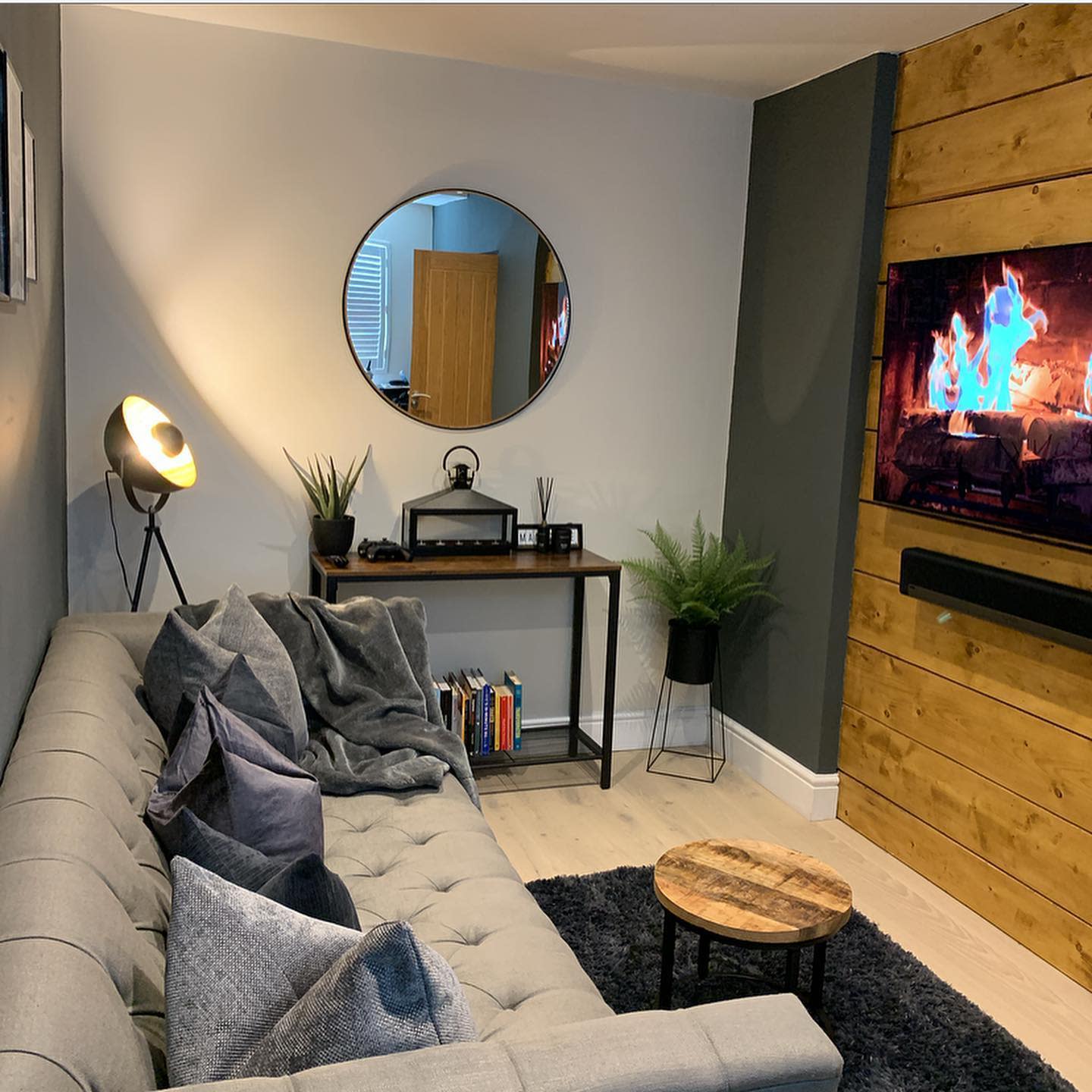 small living room wall tv with overlap, gray sofa wall mirror 