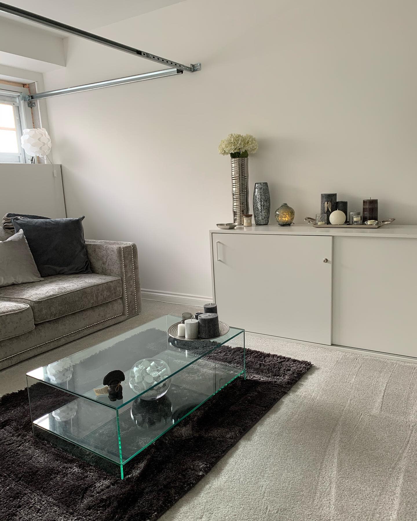 Gray sofa in garage living room and glass coffee table 
