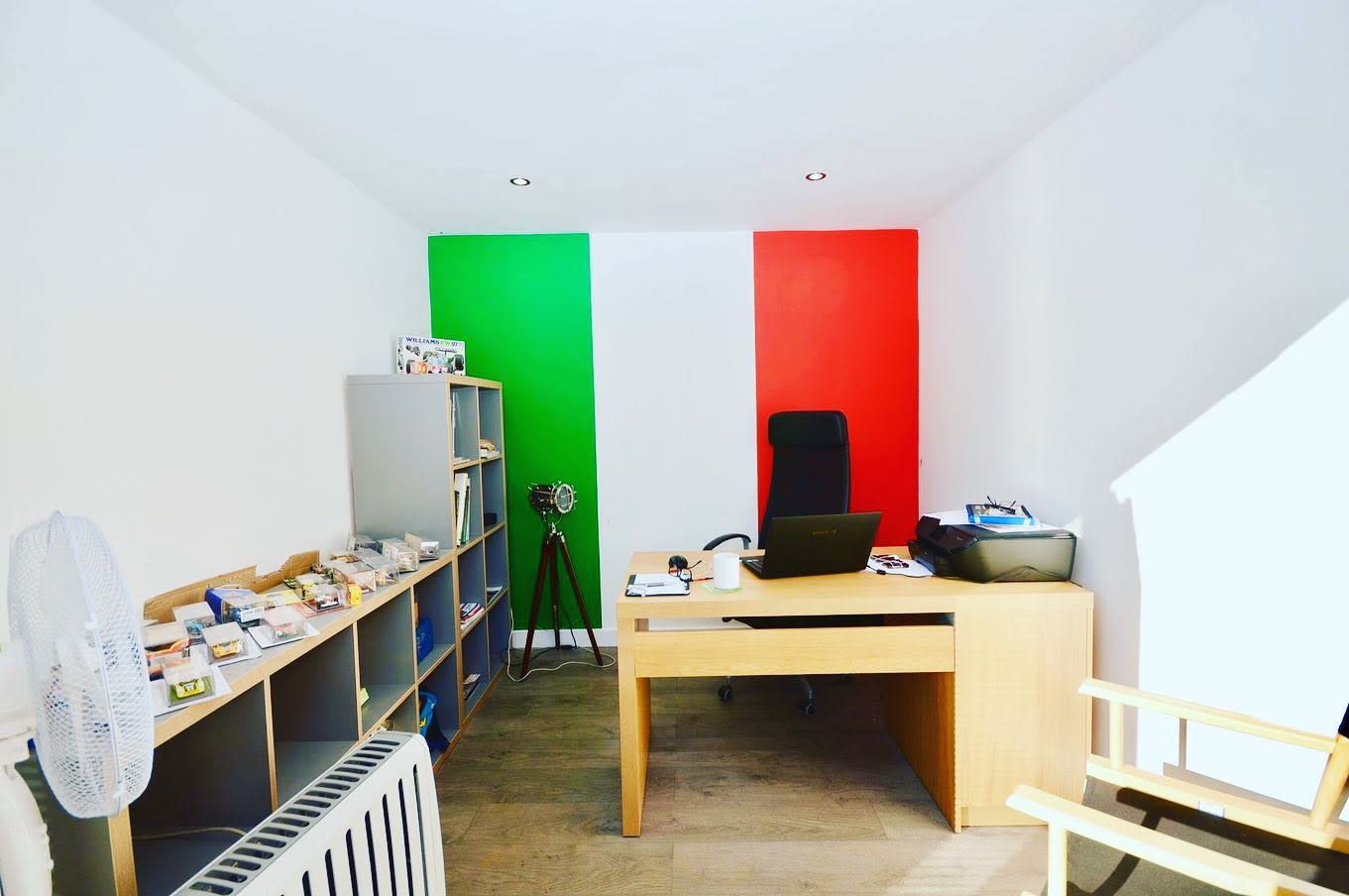 Garage office wooden desk with Italian flag on the wall 